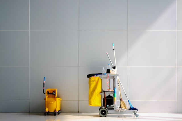 A custodian cart in front of a white wall. 