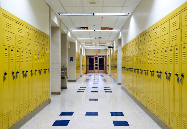 Empty school hallway with yellow lockers. 