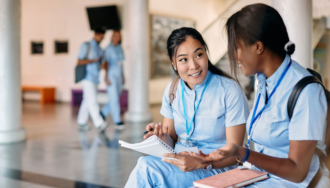 nursing students talk while studying in a hallway