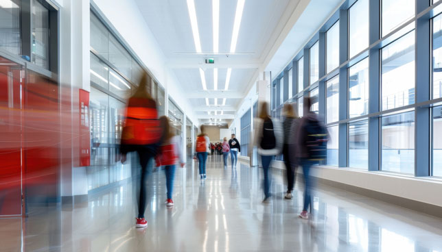 Children walking along bright school corridor with motion blur
