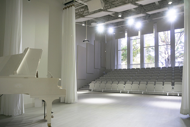Audience Systems outfitted the white box theater with custom all-white seating. 