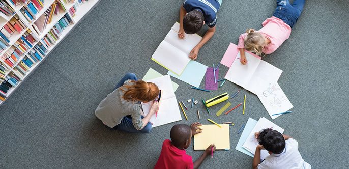 Children laying on the carpet studying